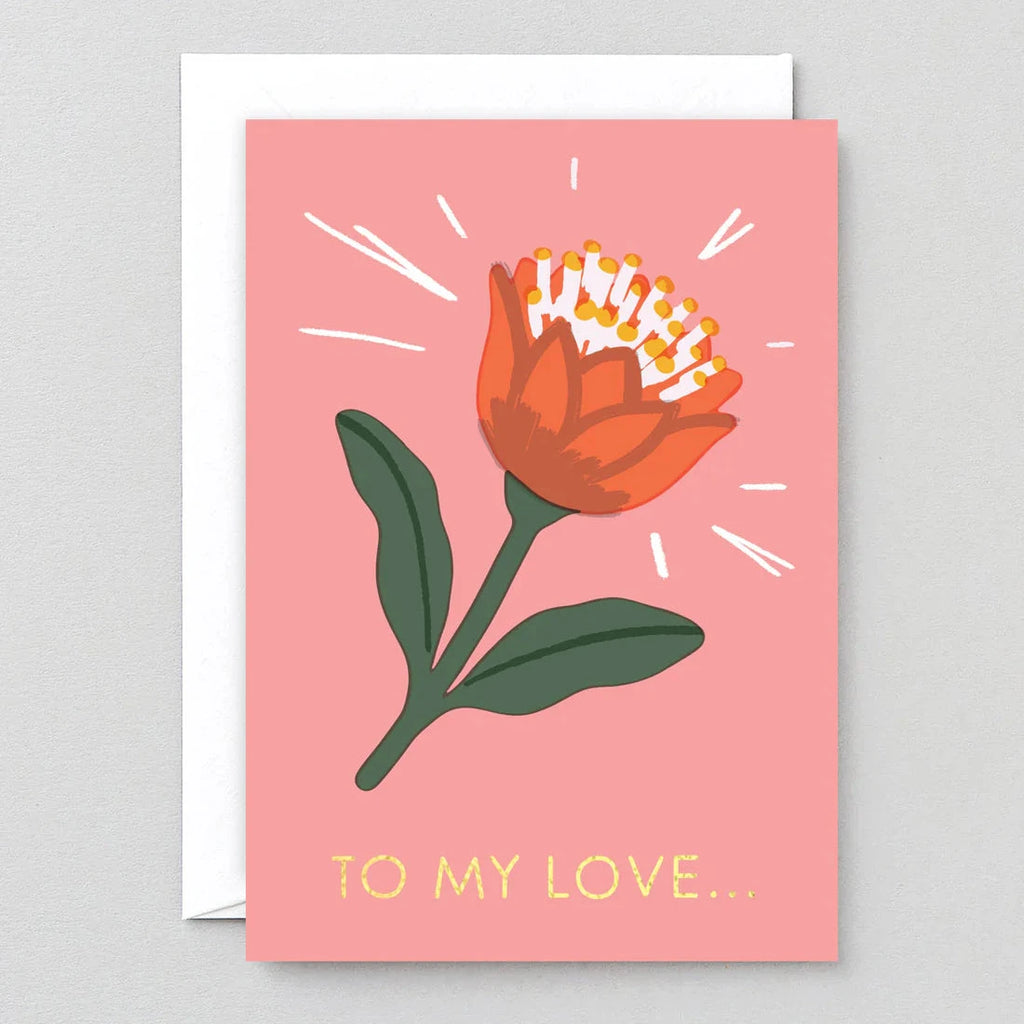 Pink greeting card featuring a stylized orange flower with gold lettering that reads "To My Love...".