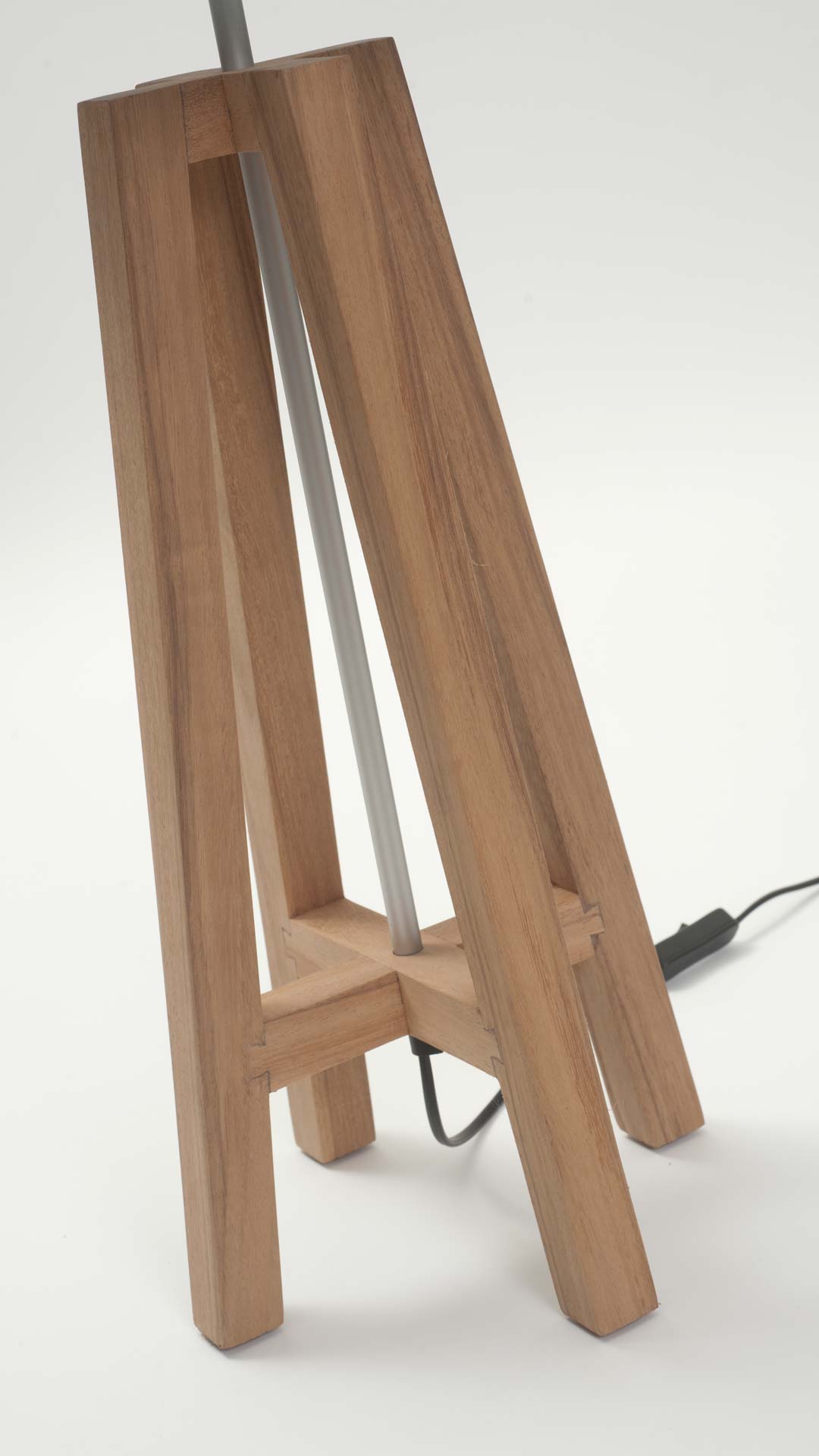 Wooden tripod base table lamp with a silver metal center pole.