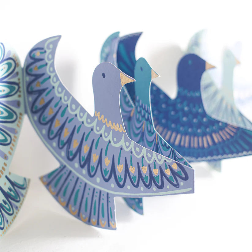 Decorative paper cutout of a blue bird with intricate patterns on a white background