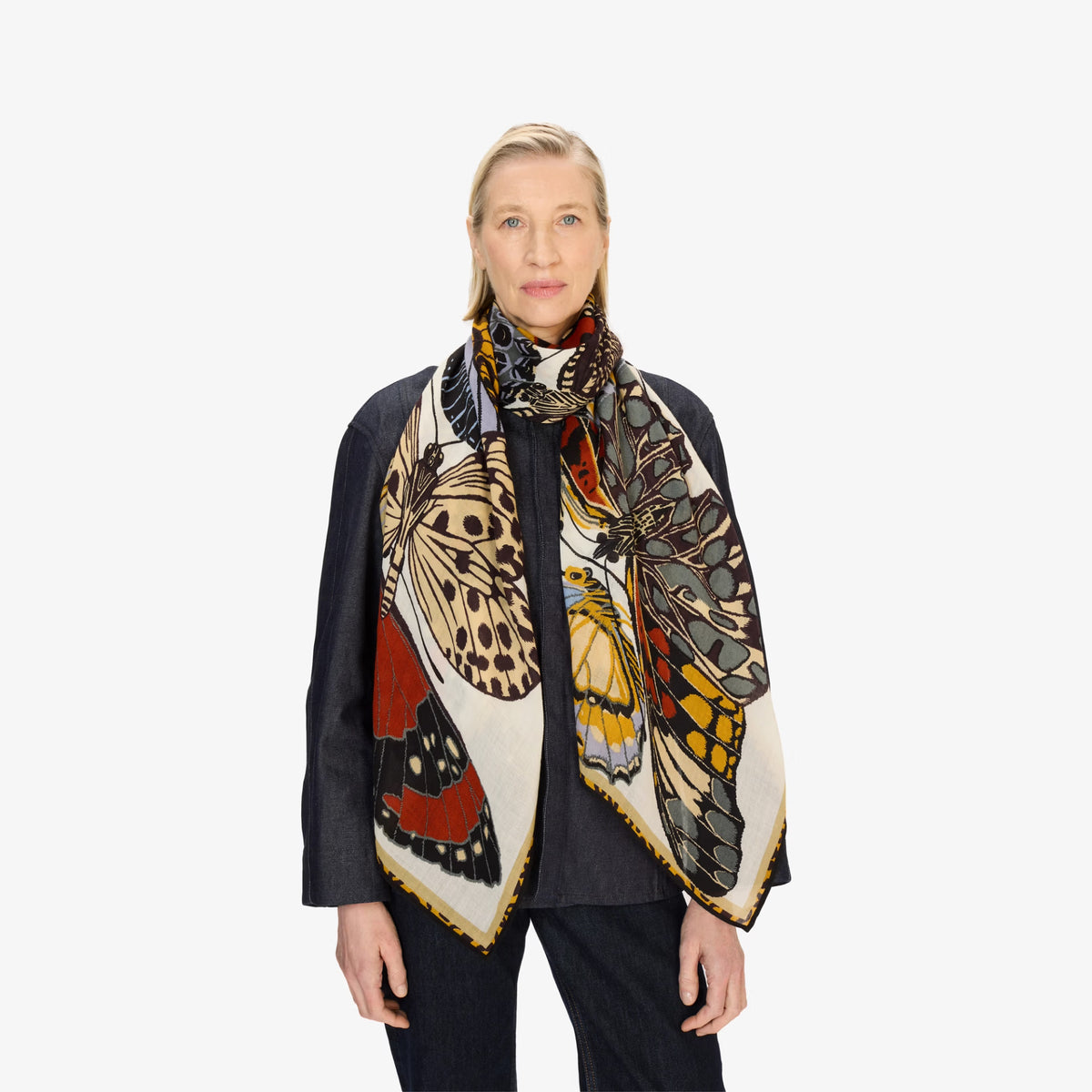 Woman wearing a colorful butterfly patterned scarf on a white background