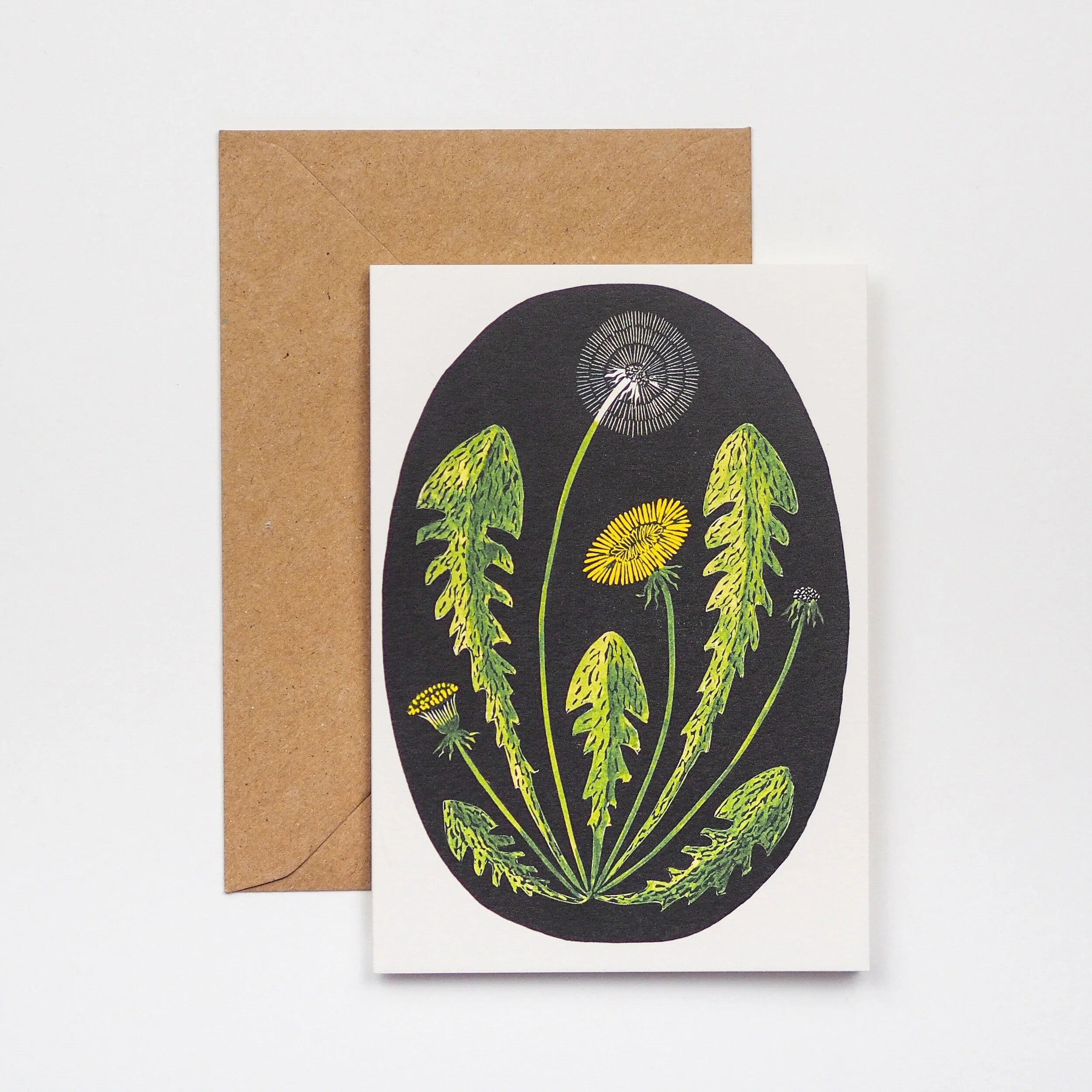 Greeting card featuring a stylized illustration of dandelions in various stages of bloom, set against a dark oval background.