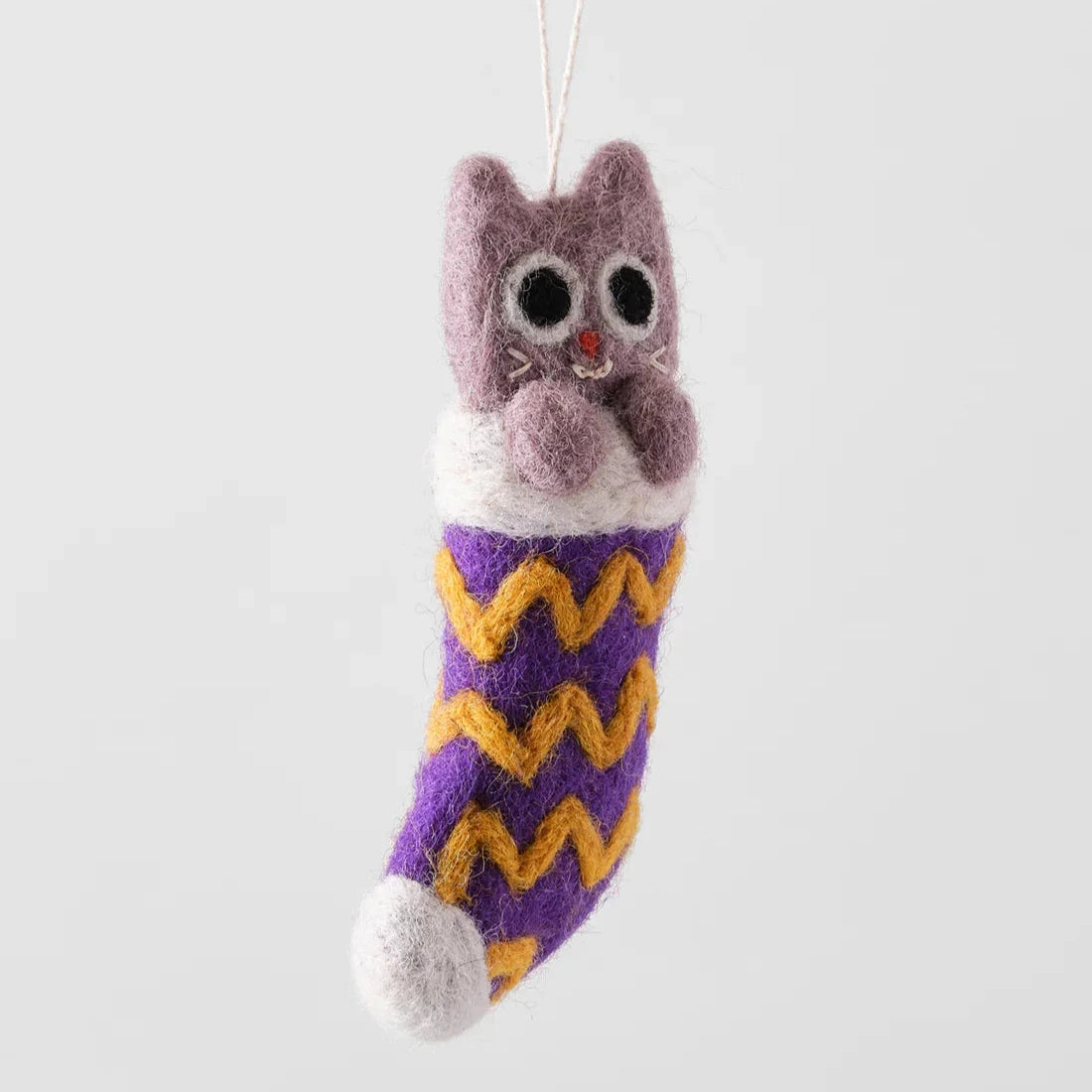 Needle-felted cat ornament inside a purple and gold stocking.