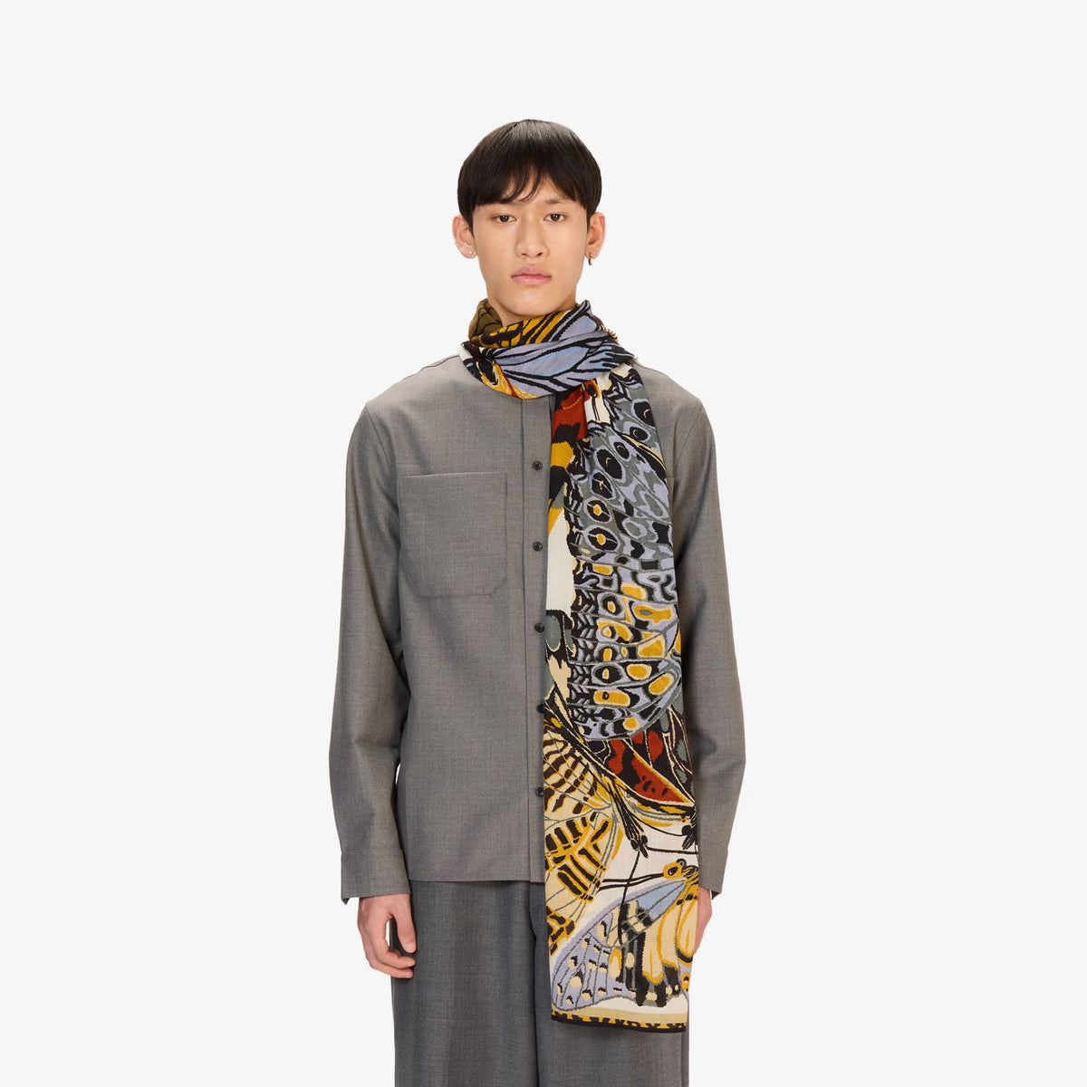Man wearing a patterned scarf on a white background