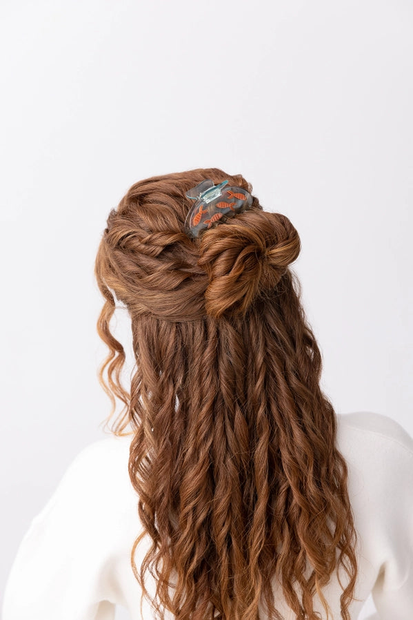 Long braided hairstyle with decorative hair accessory on a white background