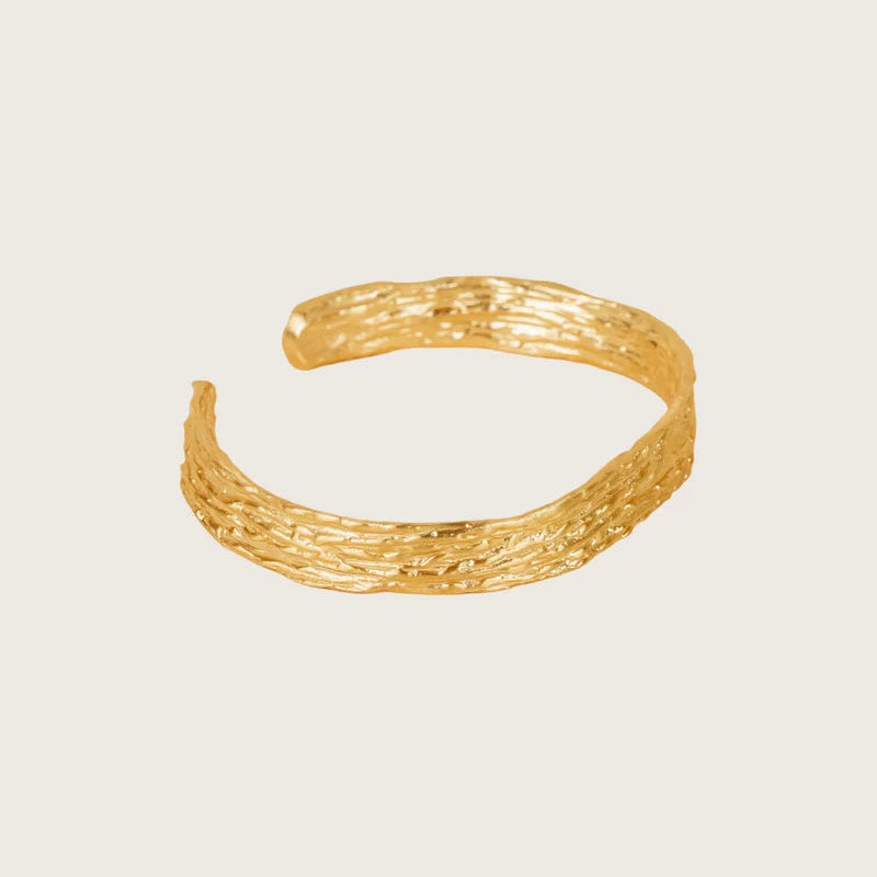 Gold bracelet on a light beige background