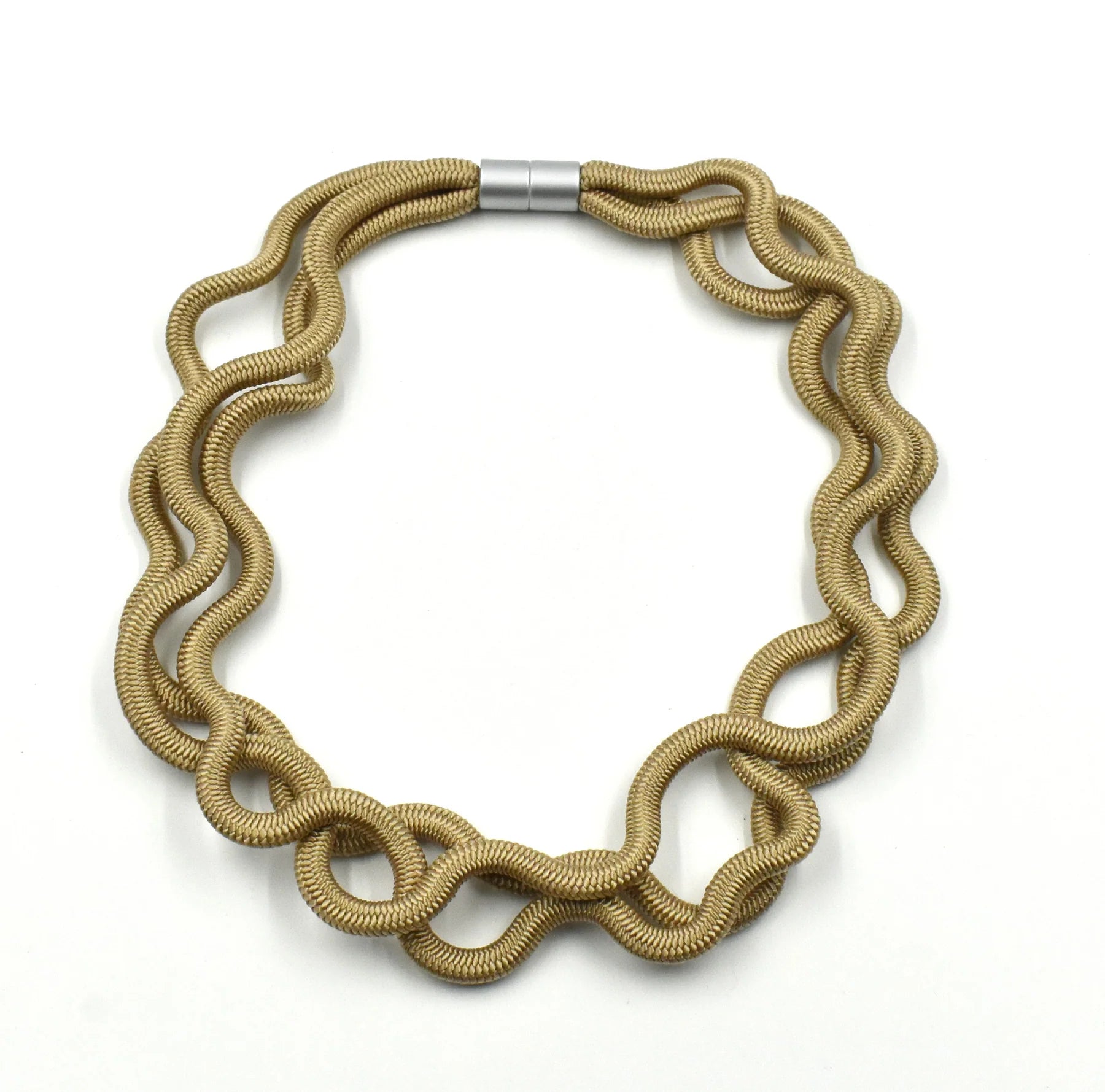 A golden coloured triple cord necklace with silver clasp sat on a white background
