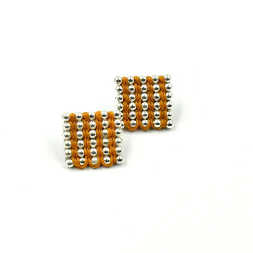 Pair of earrings with orange and silver bead design on a white background