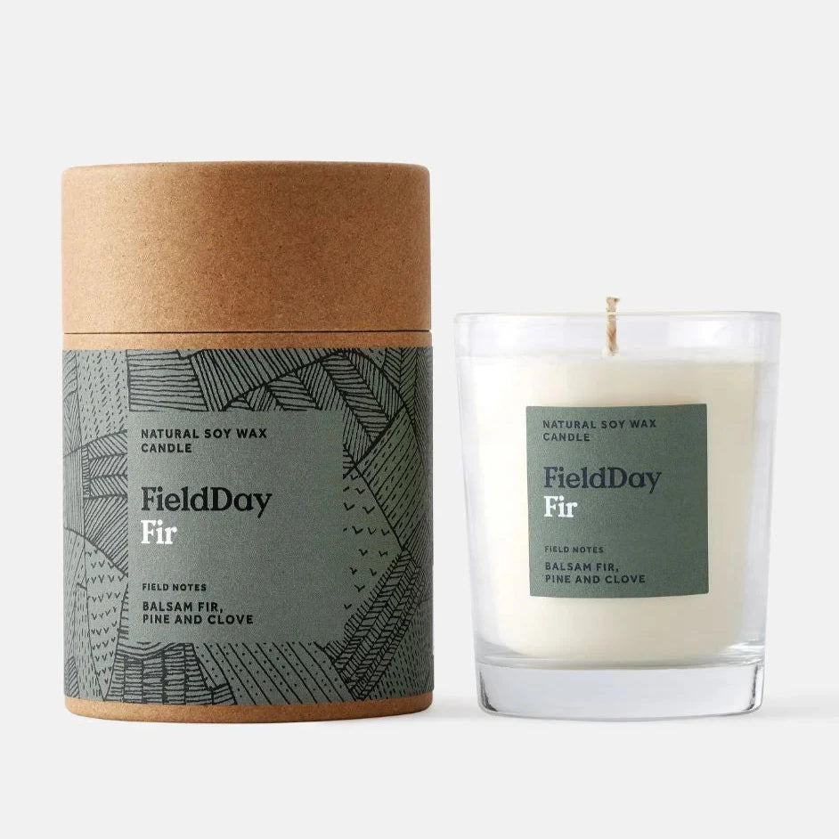 FieldDay Fir natural soy wax candle in a clear glass jar with a kraft paper tube.
