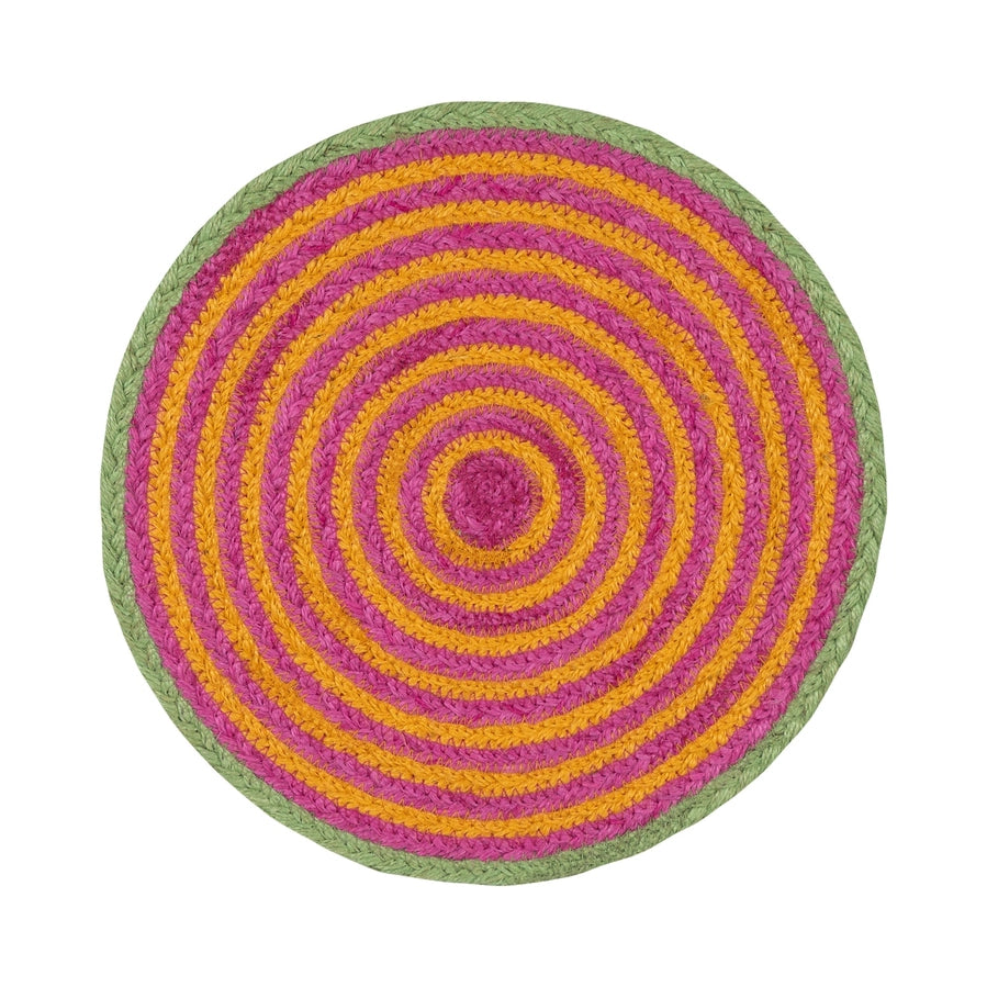 A round braided rug with concentric rings of pink, yellow, and green, photographed from directly above on a white background.
