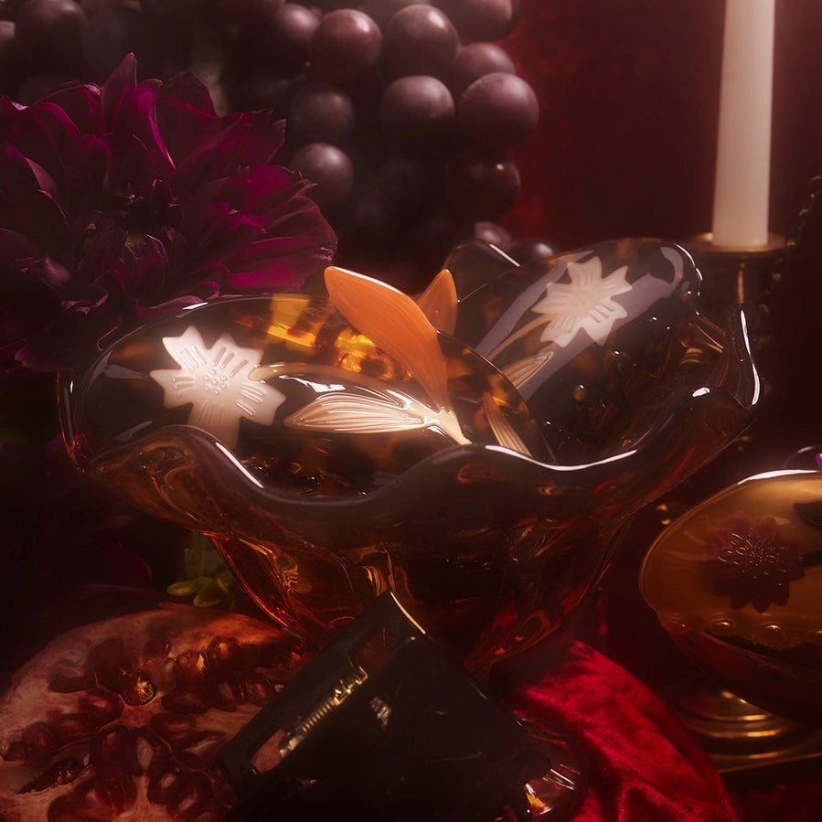 Decorative glass bowl with floral design on a dark background