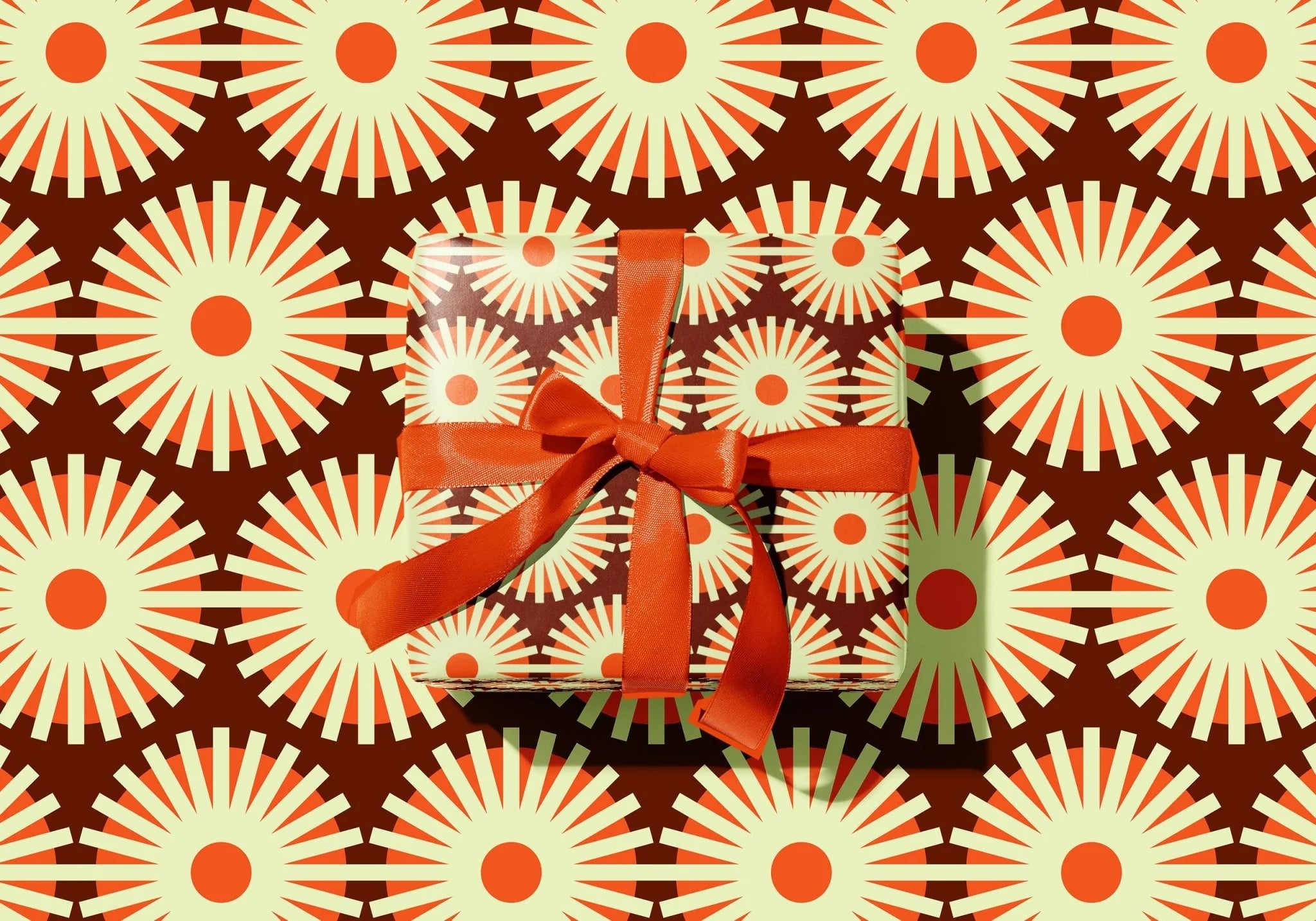 Gift box with a red ribbon on a patterned background
