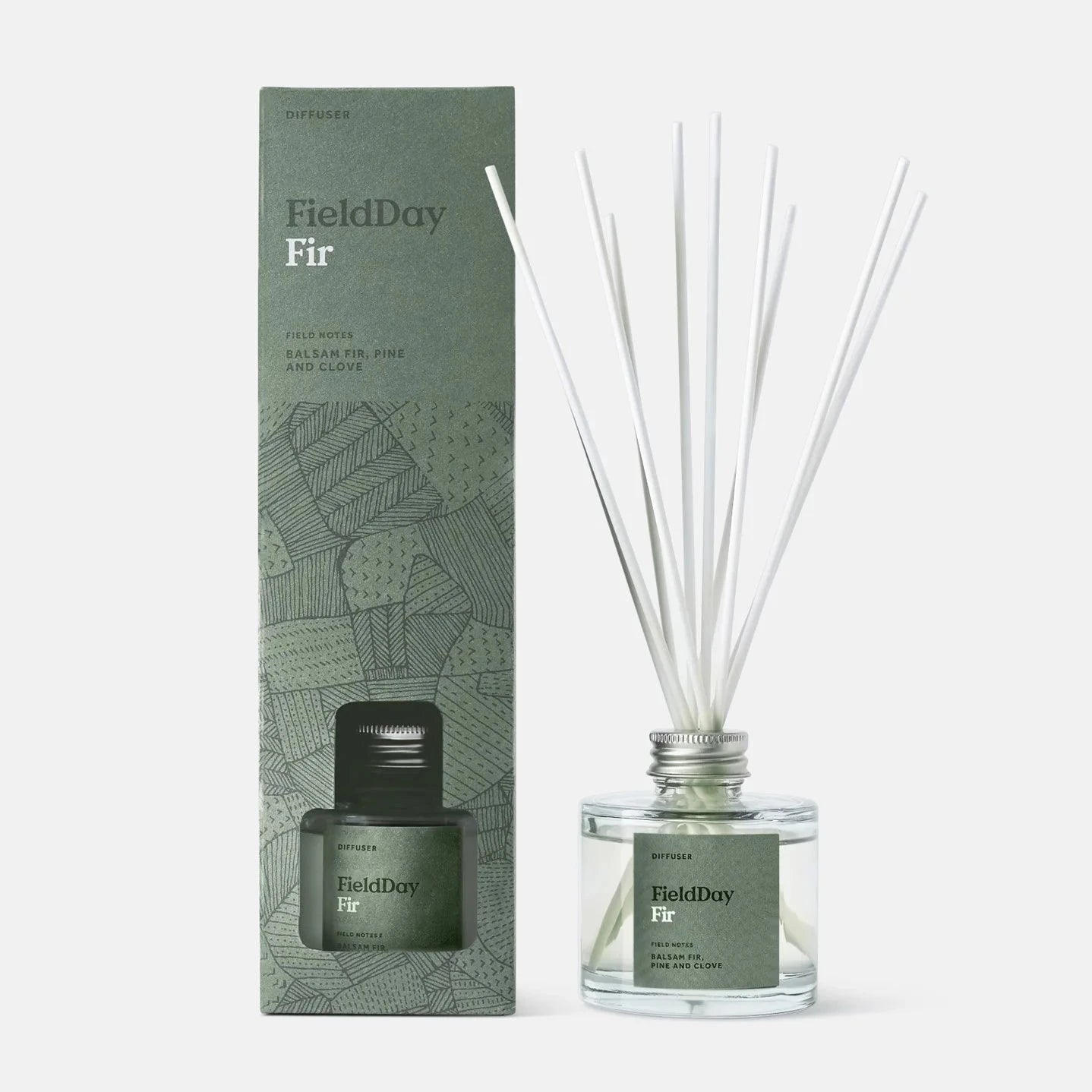 FieldDay Fir reed diffuser in a clear glass bottle with silver cap, and matching box.  Balsam fir, pine, and clove scent.