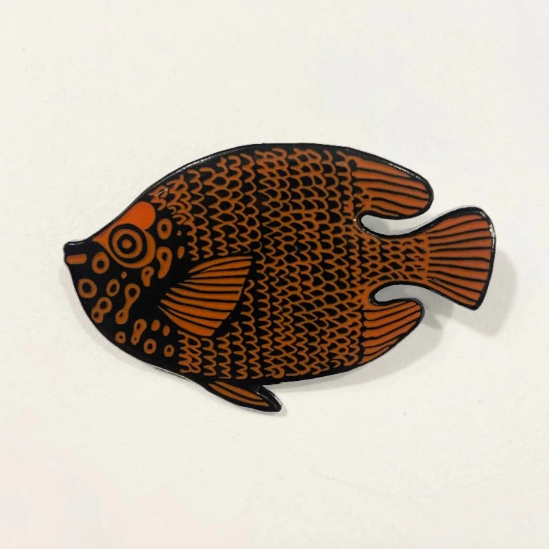 Orange and black stylized fish enamel pin.  The fish has a textured, patterned design.