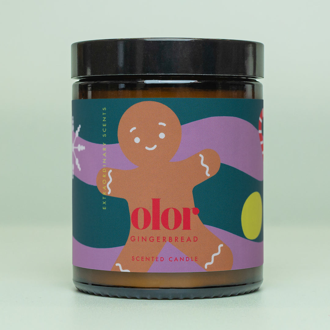 Amber glass gingerbread-scented candle with a black lid.