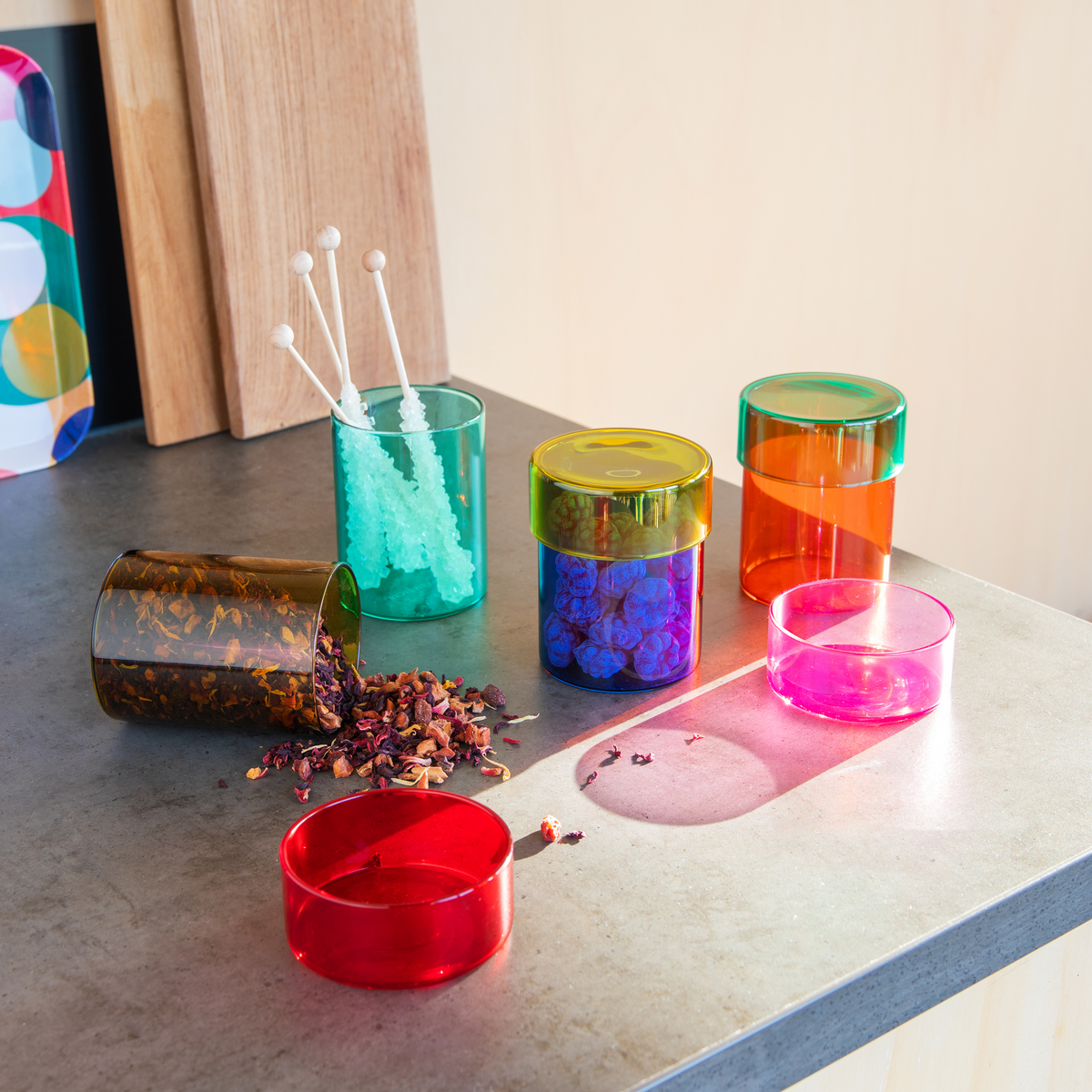 Colorful glass containers on a table with various items inside