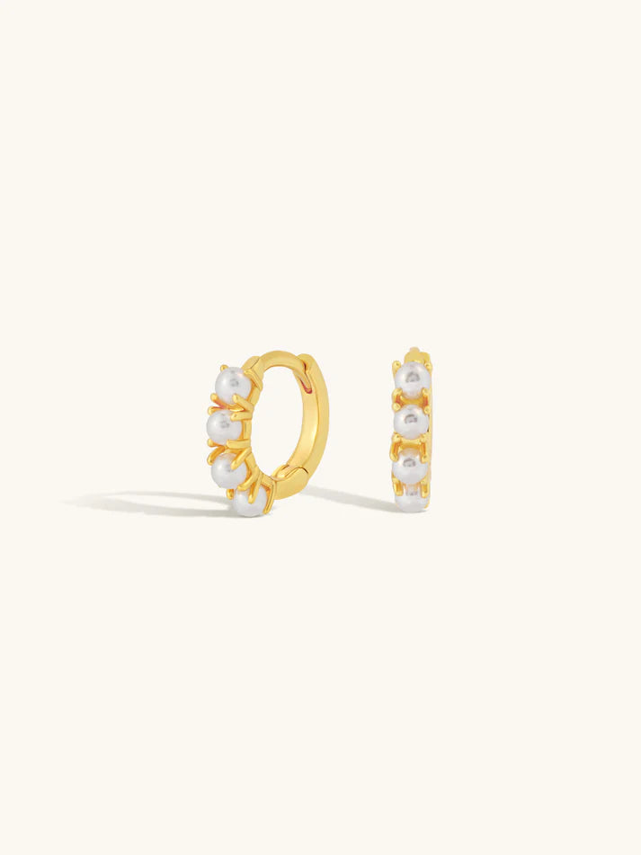 Gold hoop earrings with pearl accents on a white background