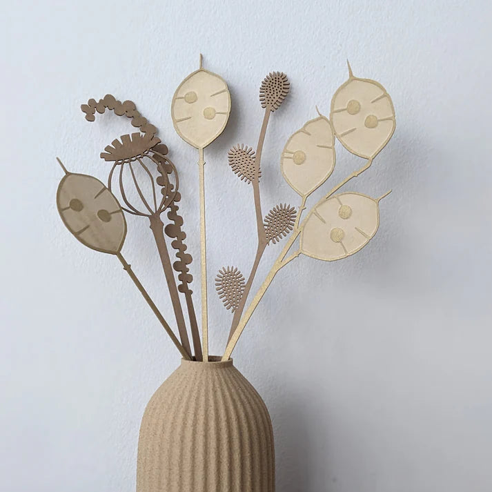 Beige and brown laser-cut wood flower arrangement in a ribbed vase.
