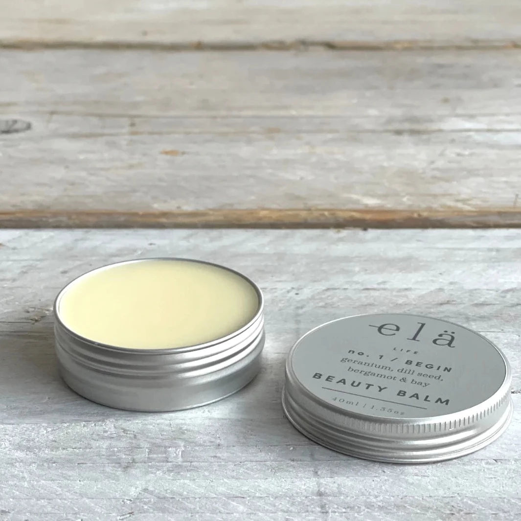 Two tins of elä Life No.1 Begin Beauty Balm, a pale yellow balm in silver tins.