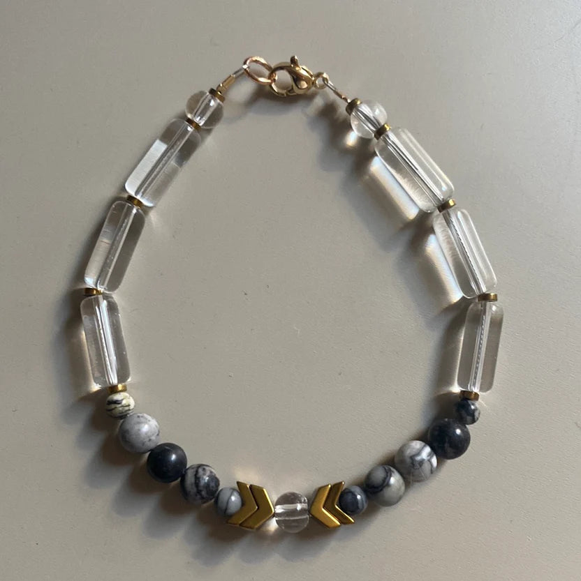 Necklace with clear and dark beads on a light gray background