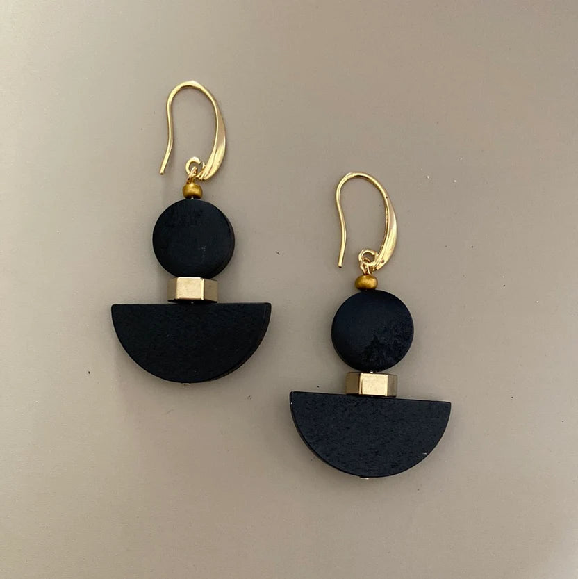 Black and gold earrings on a beige background