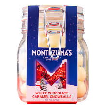 A glass jar of Montezuma's white chocolate and caramel snowballs. With a blue label with a large red M on the packaging