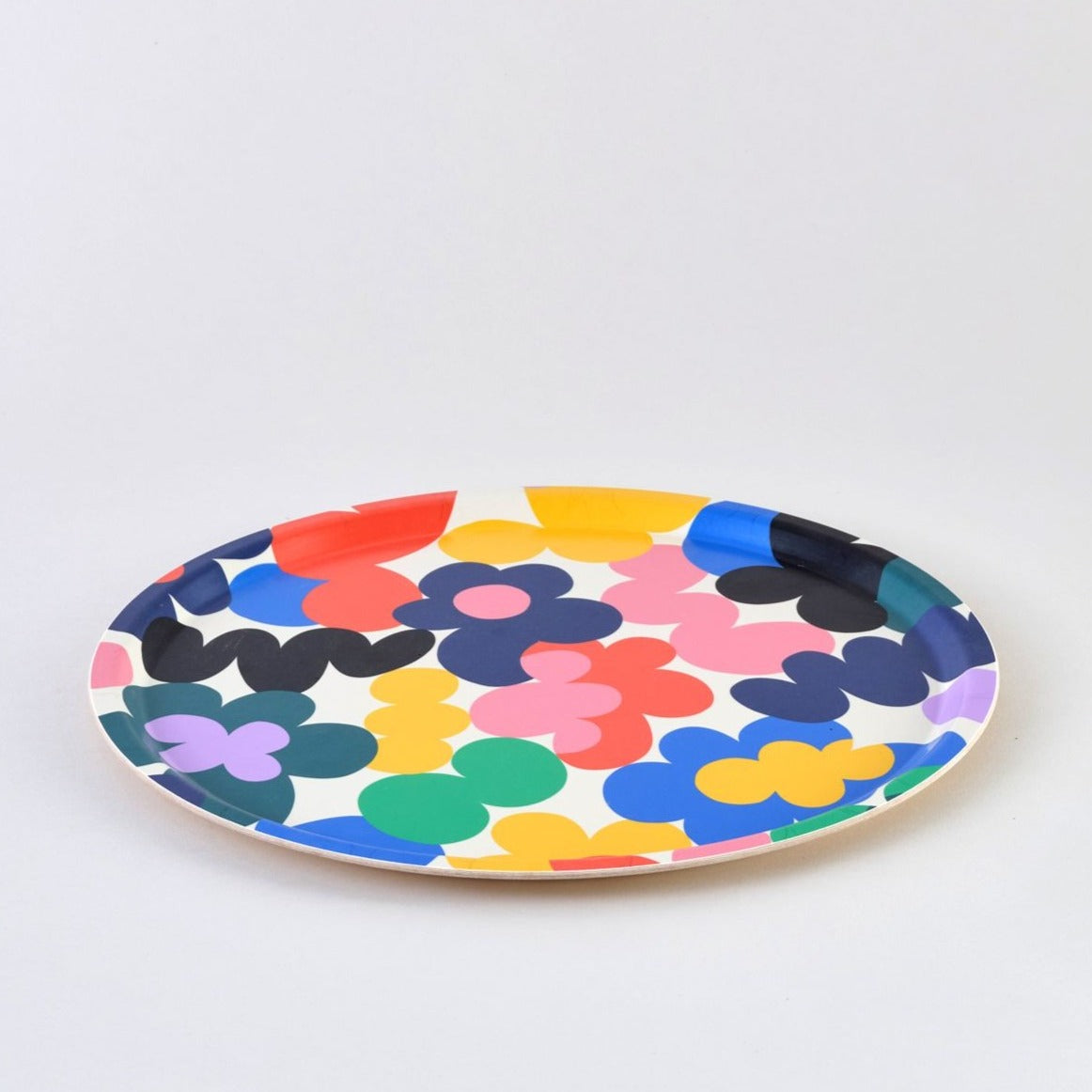Round tray with a multicolored floral pattern.