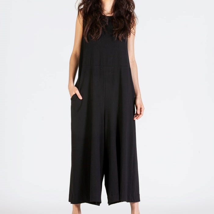 Woman wearing a black sleeveless jumpsuit on a white background