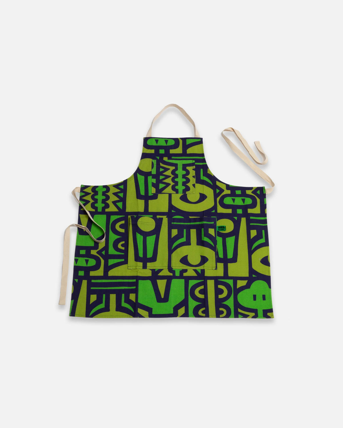 A fabric apron with a bold green and black geometric pattern, featuring beige neck and waist ties, displayed against a light gray background.