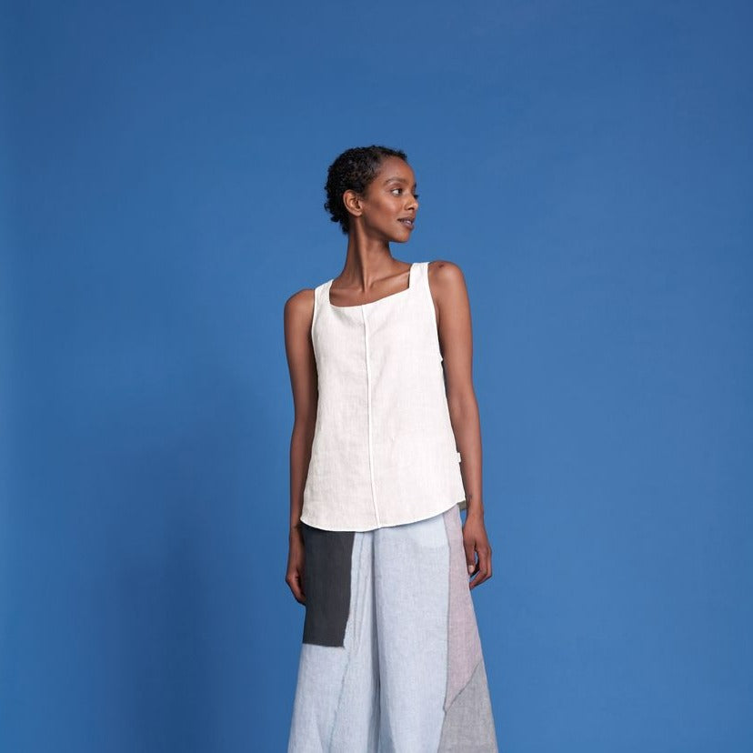 Off-white linen square-neck sleeveless top, paired with a multicolored patchwork midi skirt.