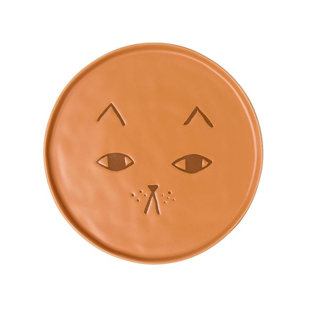 A round terracotta-colored ceramic plate featuring a carved cat face design, shown against a plain white background.