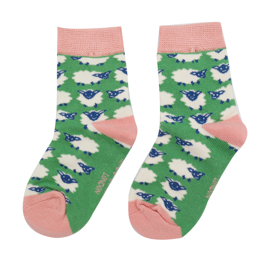 Pair of green crew socks with a repeating pattern of white sheep and pink cuffs.