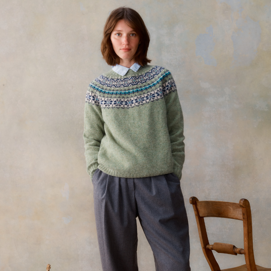 Sage green wool sweater with a Fair Isle yoke featuring teal, navy, and cream details.