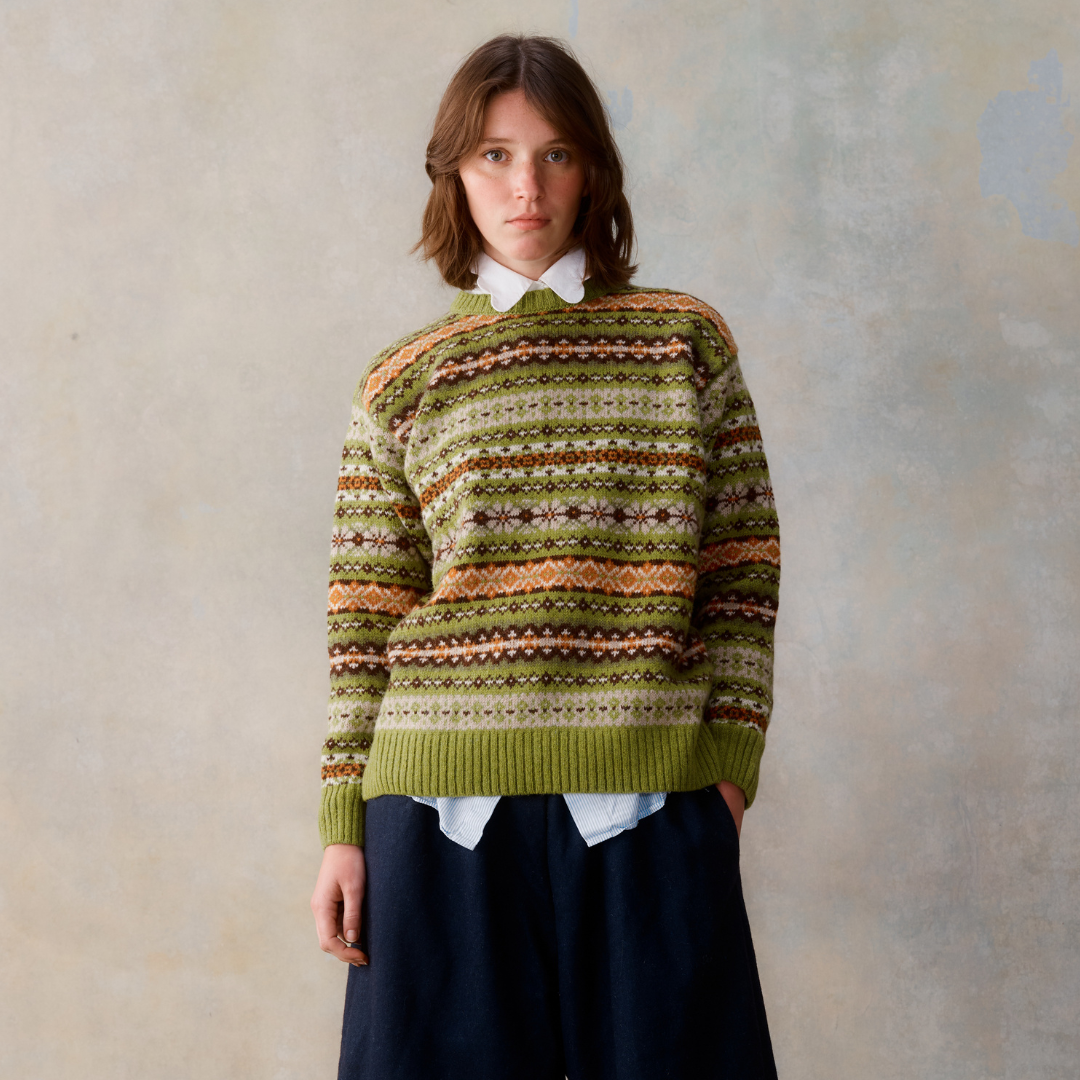 Green crewneck sweater with a Fair Isle-style horizontal patterned design in brown, cream, and olive green.