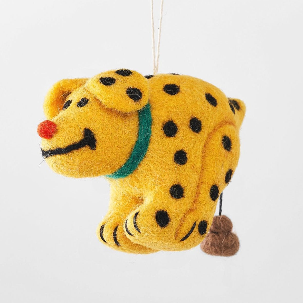 A felted wool decoration in the shape of a dog with black and yellow spots and a green collar, designed by Cari Vander Yacht.