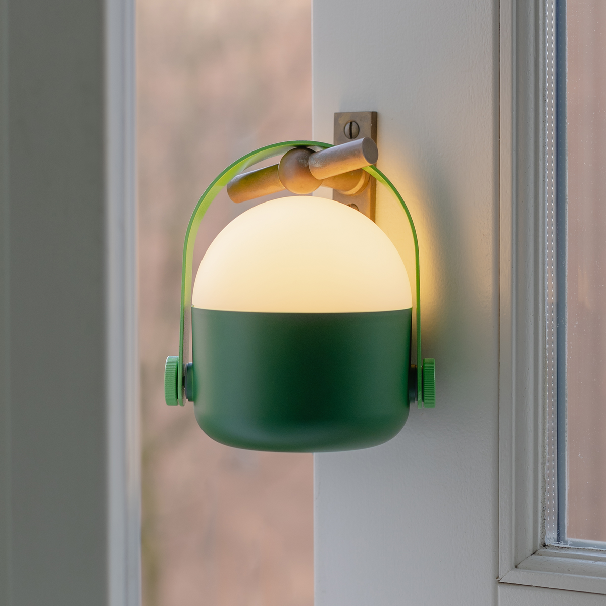Green wall-mounted lamp with a soft glow on a neutral background