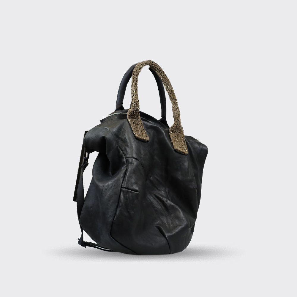 Black leather handbag with textured beige handles.