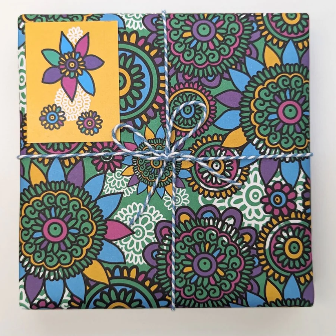 Gift wrapped in colorful floral patterned paper, tied with twine.