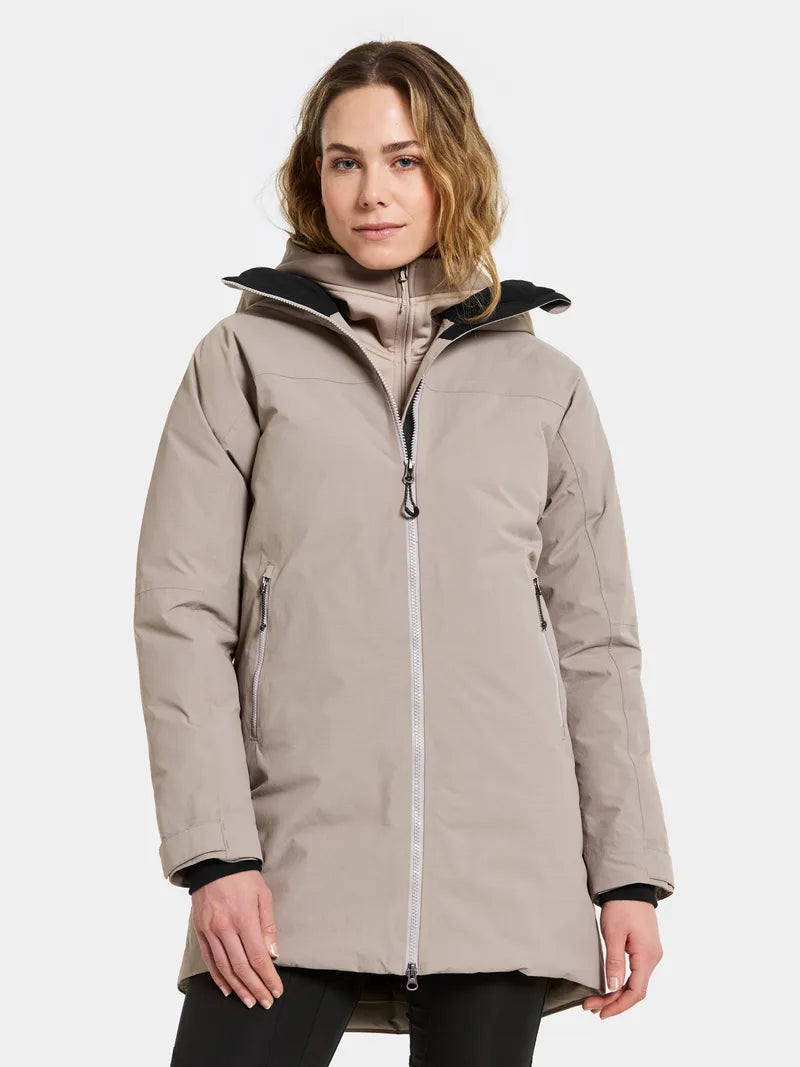 Woman wearing a beige winter coat on a white background
