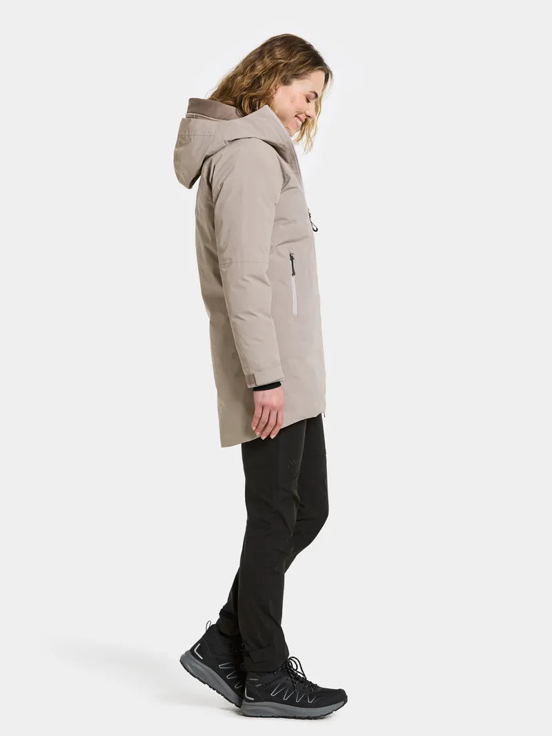 Person wearing a beige hooded coat on a white background
