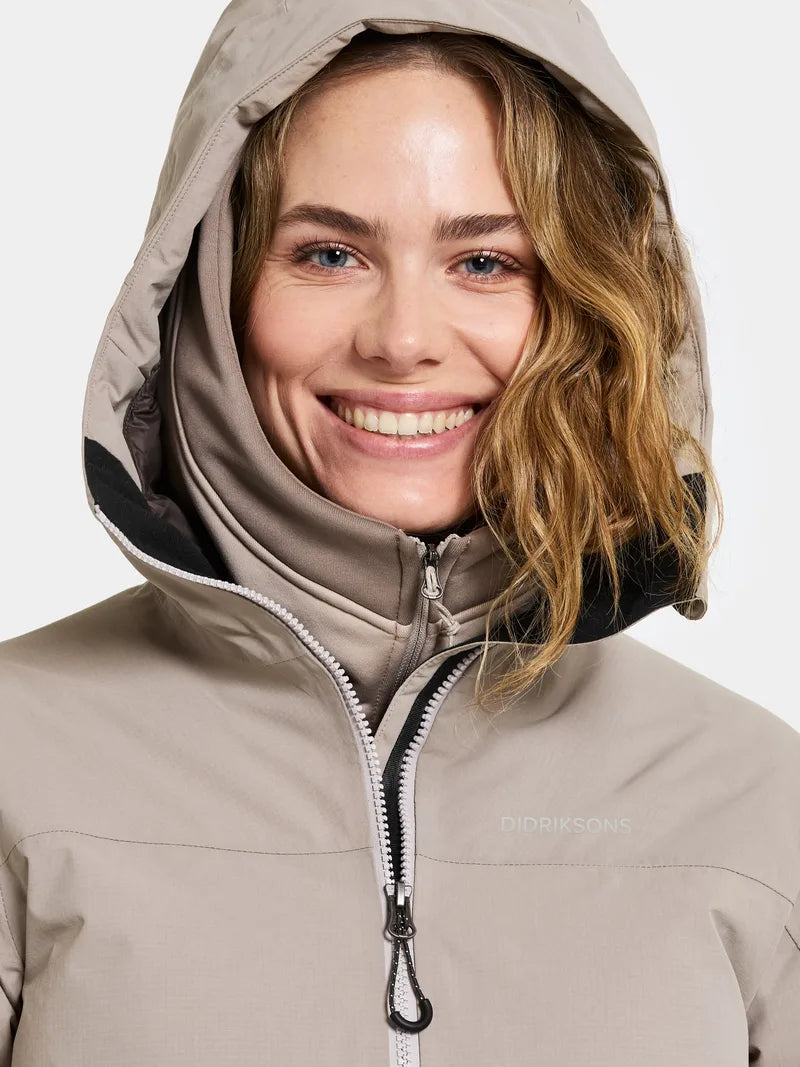 Woman wearing a beige hooded jacket on a white background
