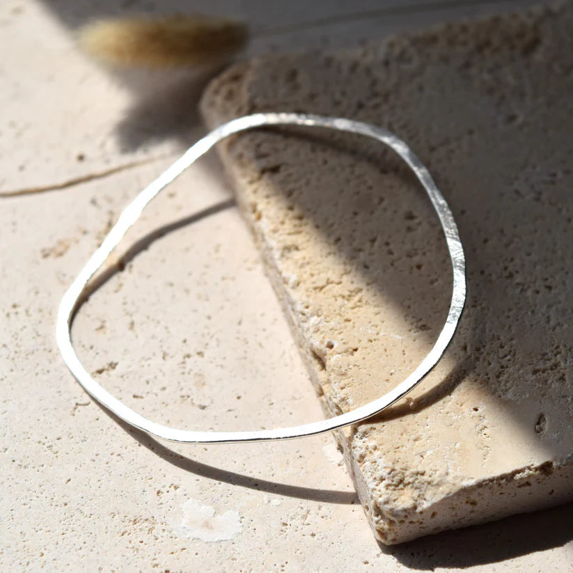 Silver hammered bangle bracelet; slightly irregular, flat oval shape.