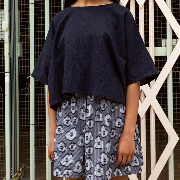 Navy blue boxy cropped top and a gray patterned mini skirt with a subtle striped texture.