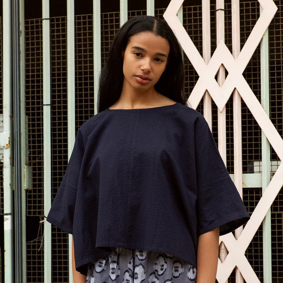 Navy blue cropped boxy top with short sleeves and textured fabric.