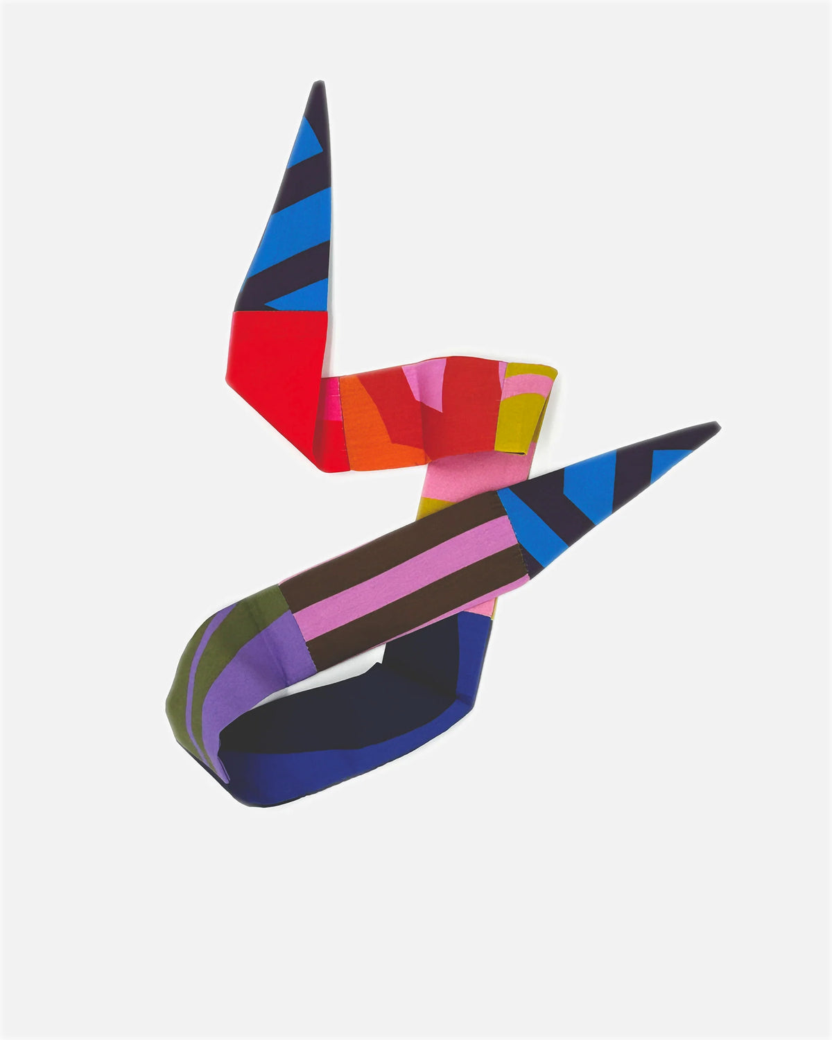 A colorful abstract ribbon sculpture with geometric blocks of blue, red, pink, yellow, brown, purple, and green, set against a solid light gray background.