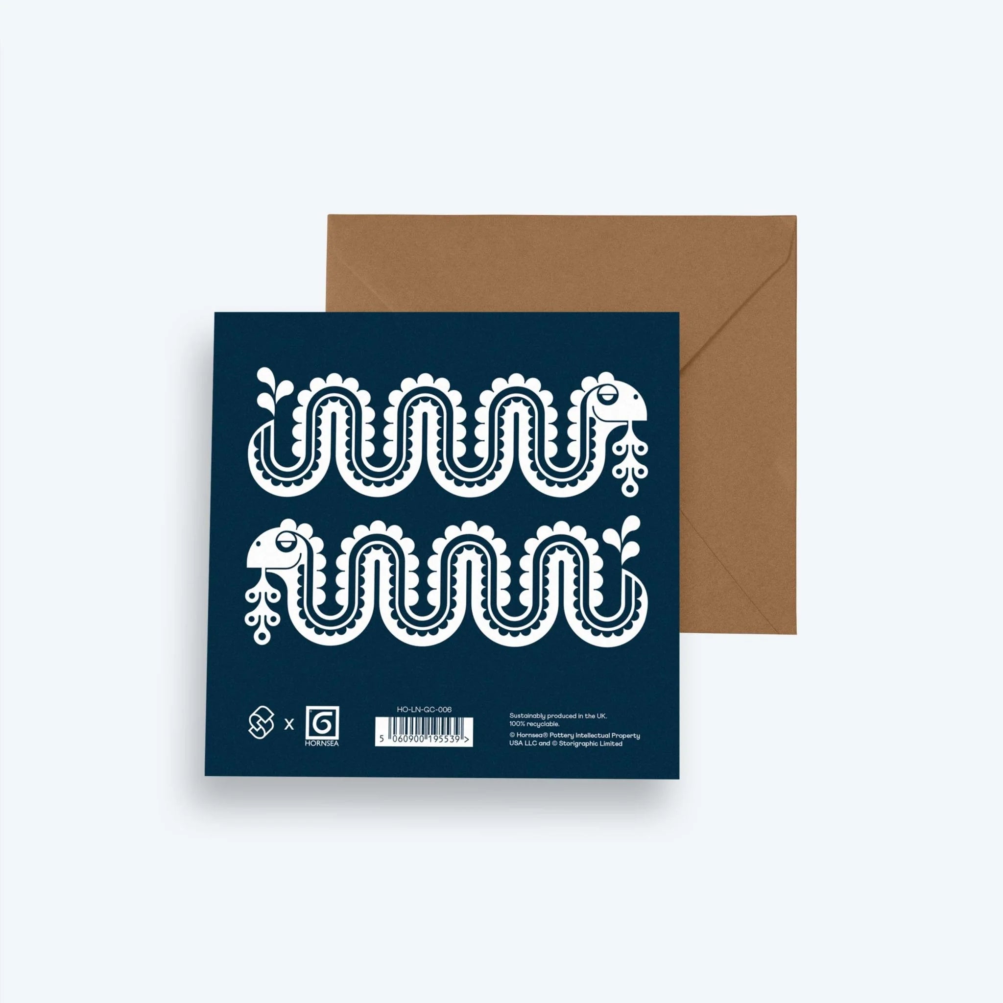 Navy blue card with white decorative patterns and a brown envelope on a light gray background