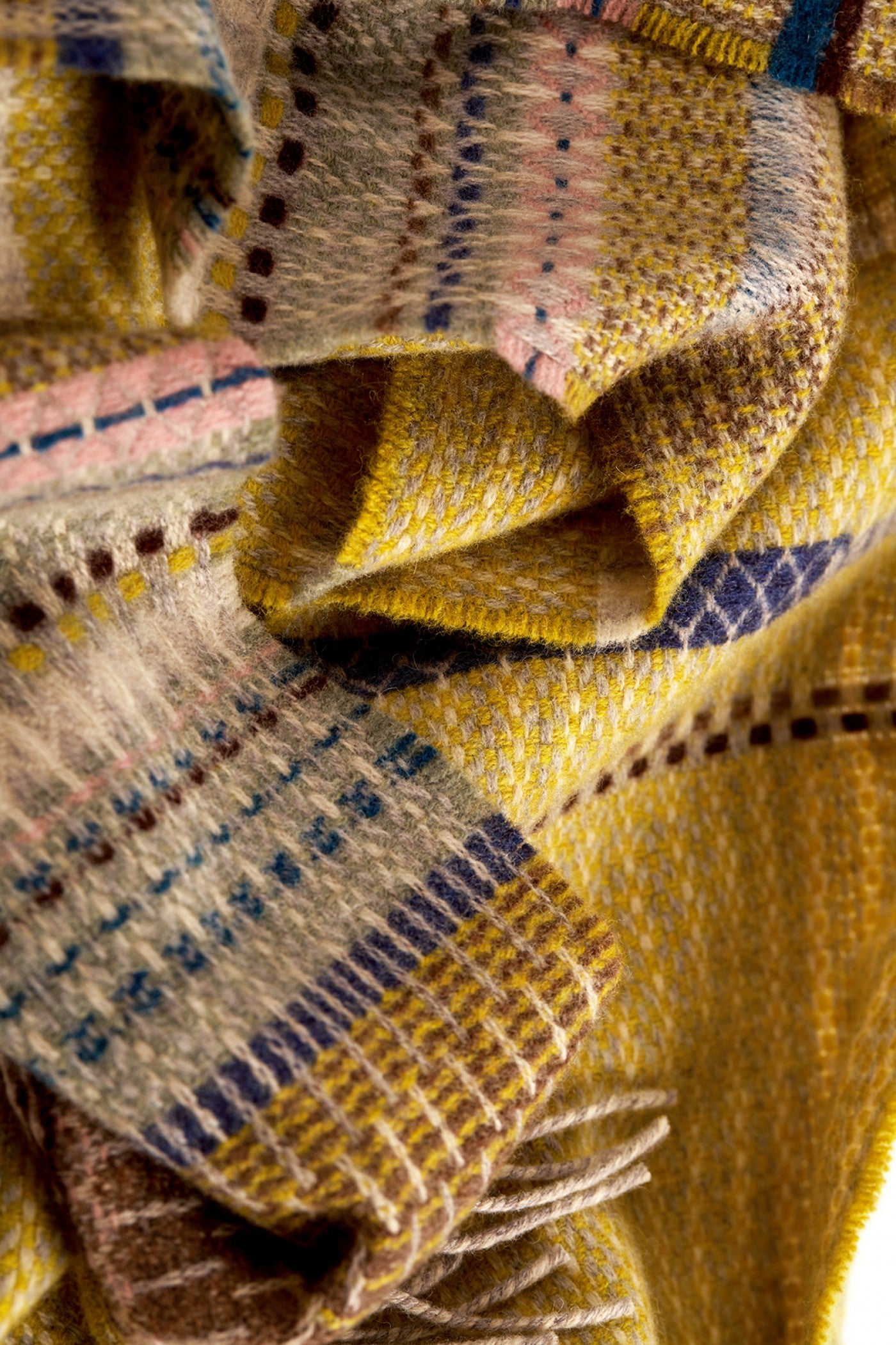 Close-up of a plaid fabric with yellow, brown, and blue patterns.