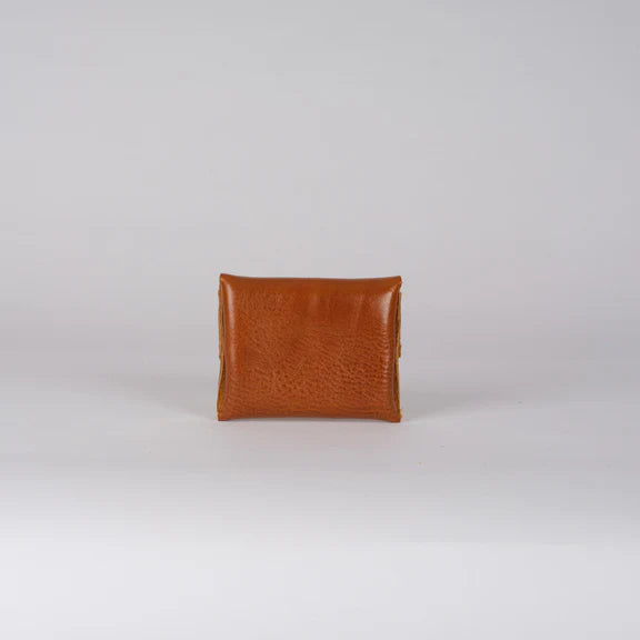 Small, light brown leather wallet.  Closed, showing textured surface.