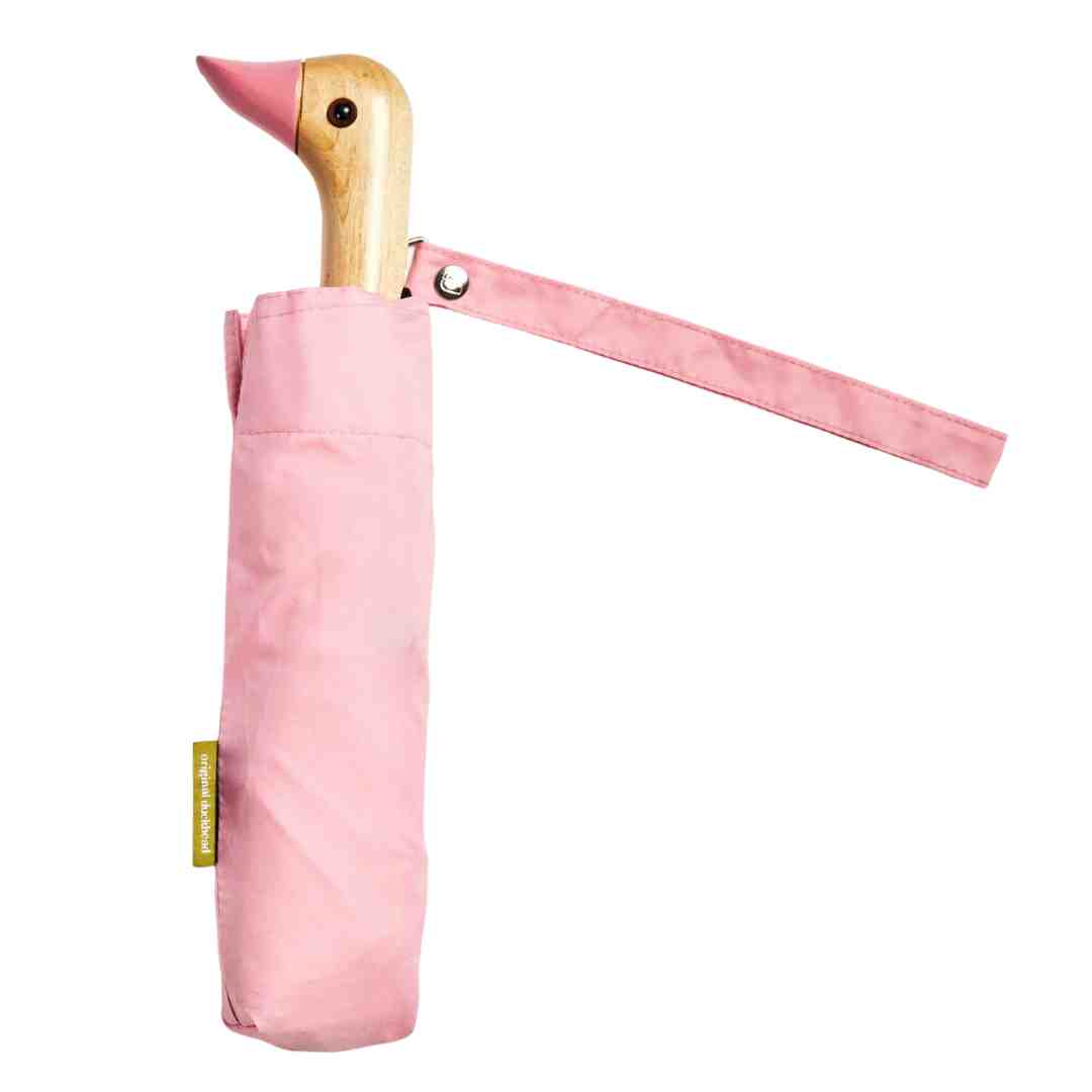 Pink compact umbrella with a wooden duck-shaped handle.