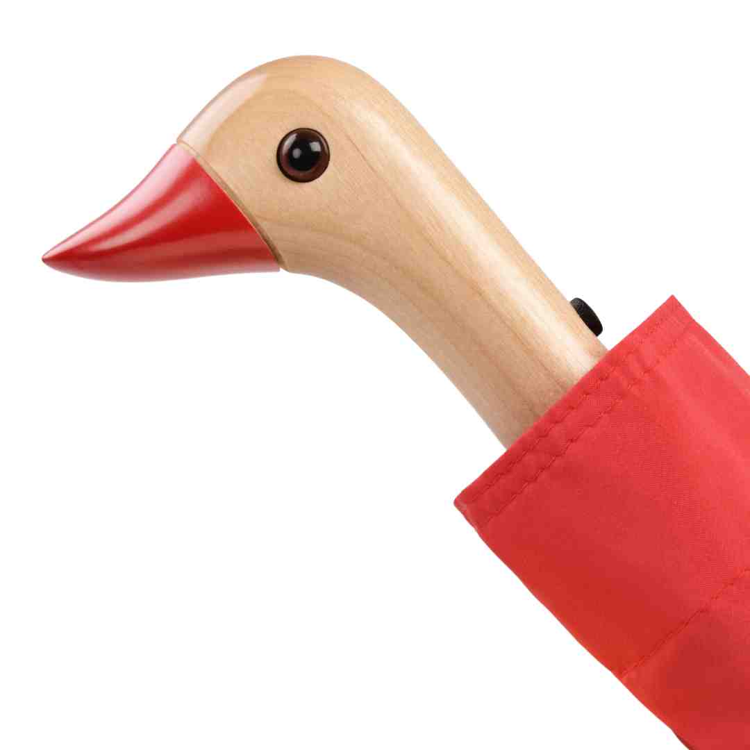 Red umbrella with a wooden duck-shaped handle.  The duck's beak is red, and it has a dark eye.