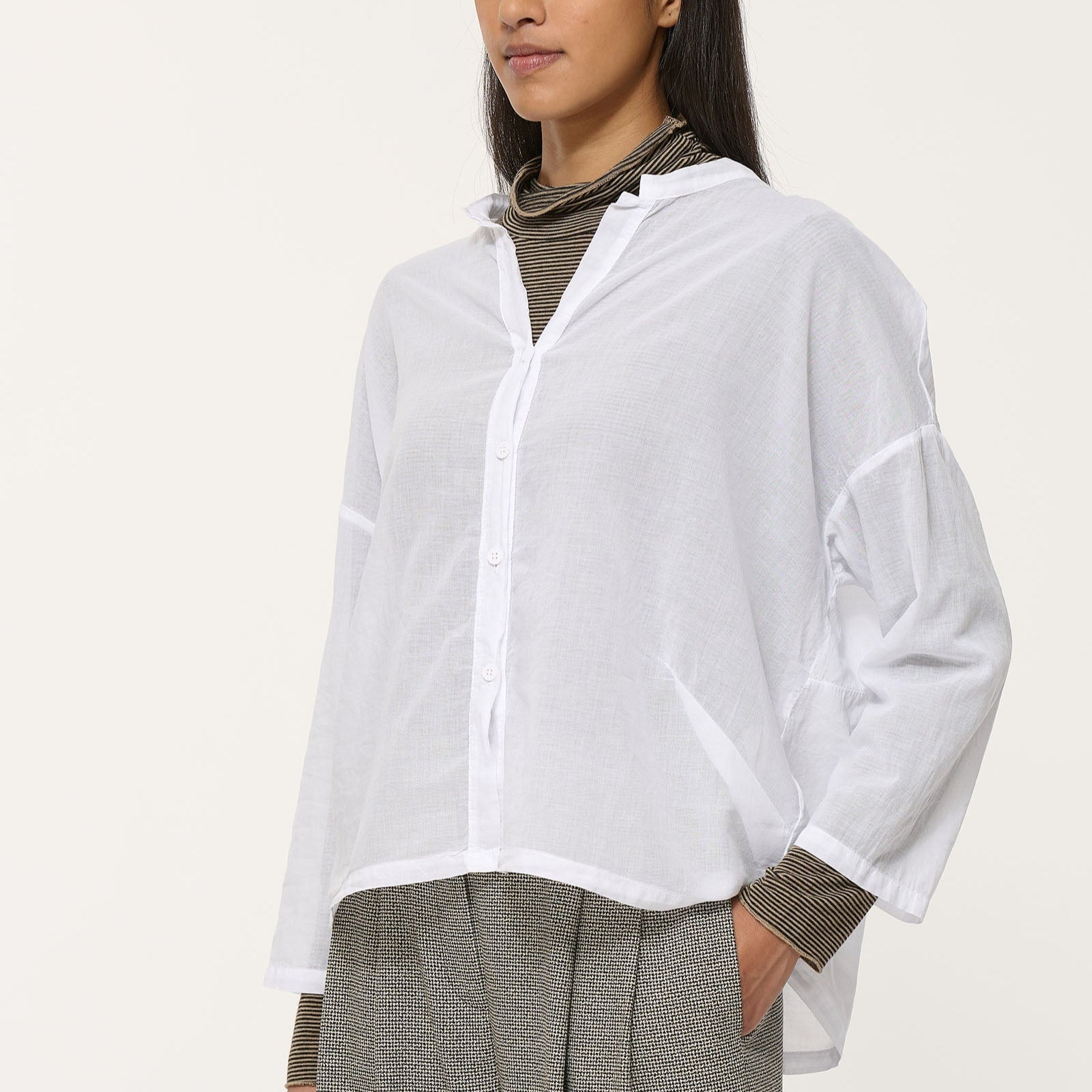 White oversized button-down shirt with long sleeves and a relaxed fit.